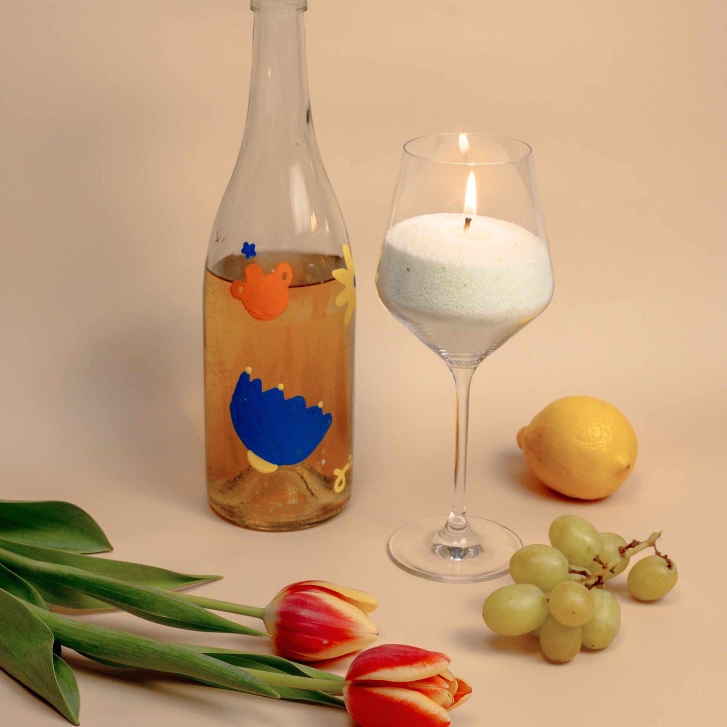 Candles lighting in a wine glass, showcasing the versatility of sand candles.