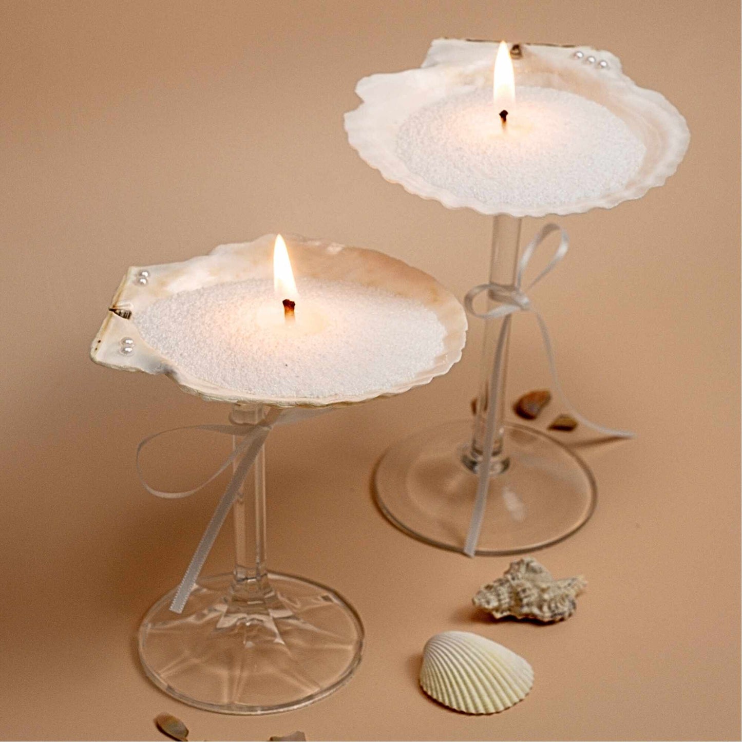 Candles lighting in a seashell martini, showcasing the versatility of sand candles.