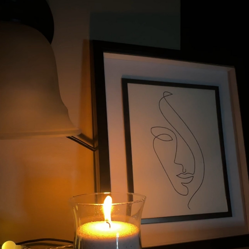 A candle filled with Candella's sand wax, placed in an aesthetic corner of the bedroom.