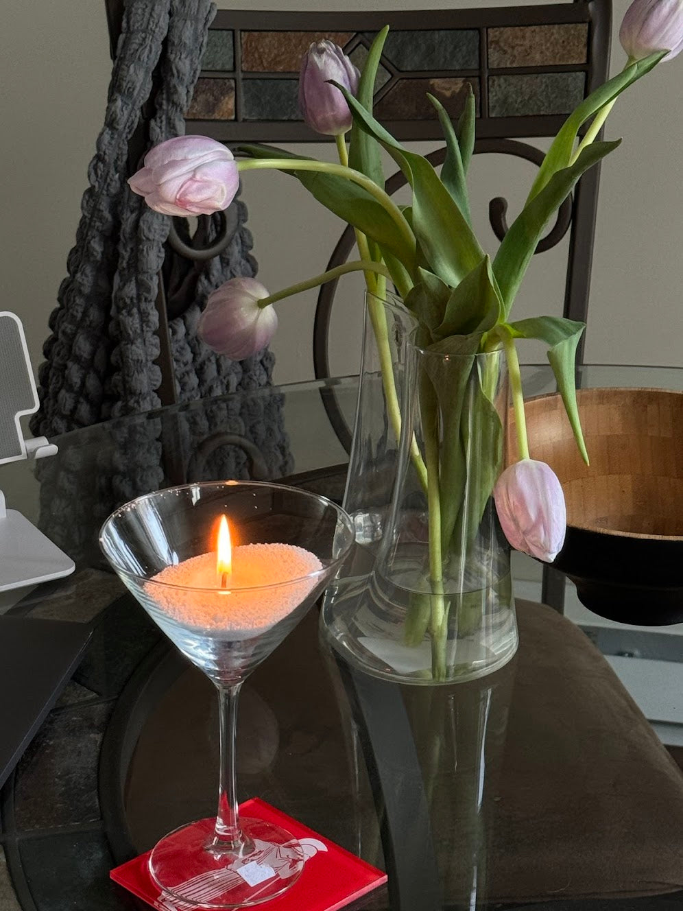 A martini glass filled with candella's sand candle on a dining table.