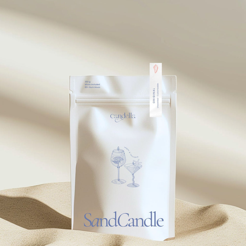 A product image of Candella's Sand Candle. The minimalist, cream-coloured pouch features a subtle illustration of two cocktail glasses with text that reads "Vegan & Reusable." A small label at the top right corner of the package indicates the scent "Original- Unscented & Customizable" 