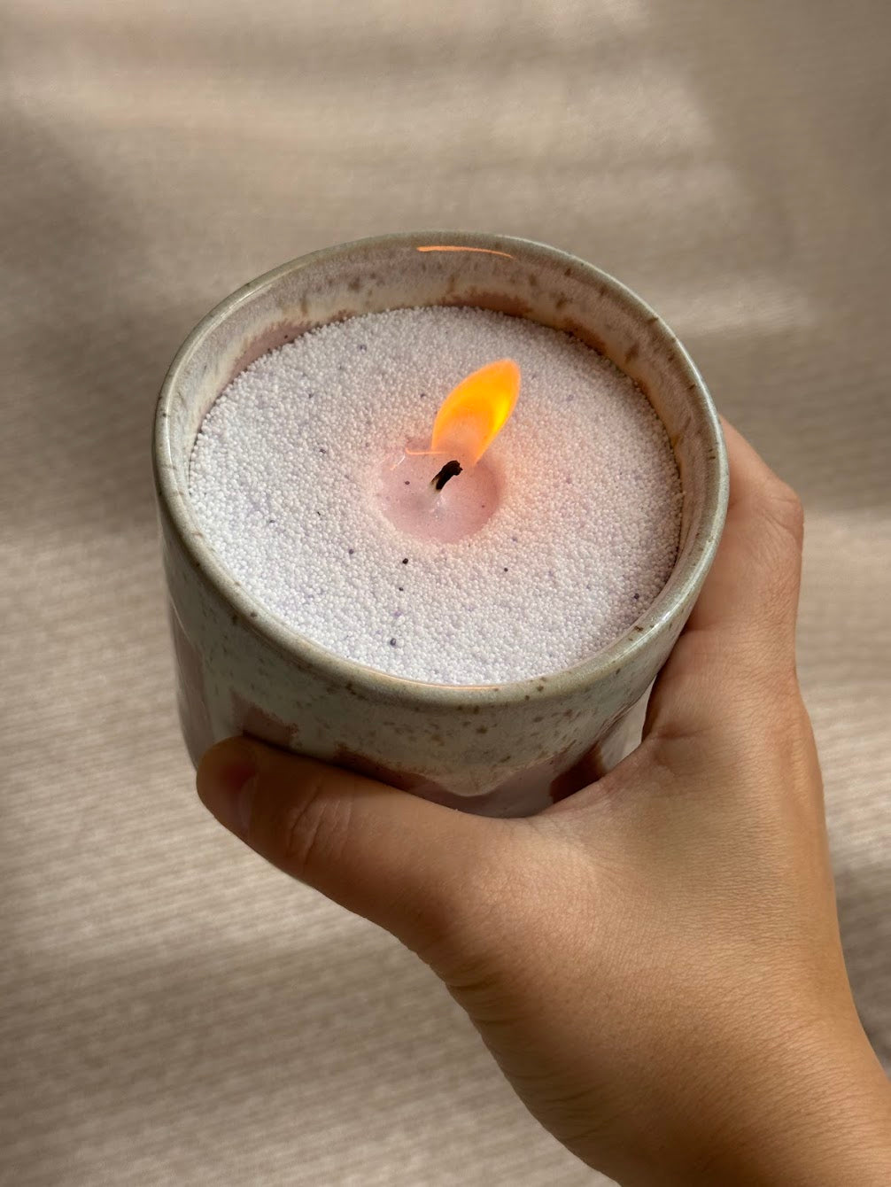 holding a raku pottery candle lighting using sand candle